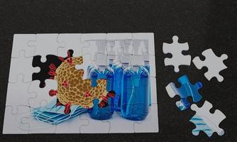 jigsaw picture overlap, the background is a Coronal Covid-19 virus and the picture above is a puzzle mask and an alcohol gel. Conceptual image of preventing germs with virus masks. 3D Rendering photo