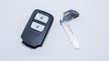 The car remote key has a black frame with 2 keys for Lock and Unlock placed on a white surface or background. photo