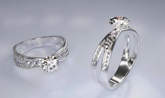 anillos de diamantes hechos de oro platino decorados con muchos pequeños diamantes colocados sobre una superficie blanca. representación 3d foto