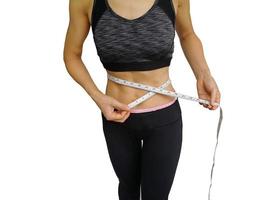 40-year-old housewife with exercise and health care. Girl in exercise clothes And waist tape measure Sports bra and exercise pants. The girl in the body fit and firm. photo