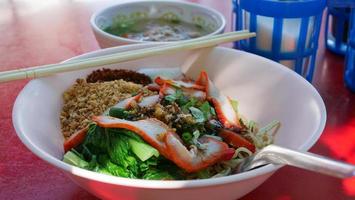 Dry red pork noodles. Yellow Noodles and Boiled Vegetables Topping with Roasted Pork. Famous Street Food in Thailand. photo