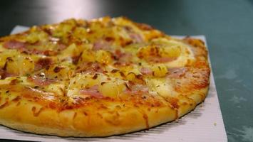 Pizza de chorizo y jamón con queso. la pizza en la caja de entrega diaria fue entregada sobre la mesa de mármol. foto
