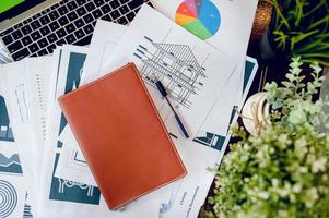 A desk with a business notebook, chart and table top. Top view with copy space photo