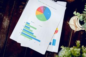 Business desk with business notebook, graph paper, pen on desk, top view with copy space. photo