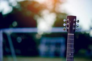 Guitar is placed in a green lawn. Musical concept And there is a copy space. photo