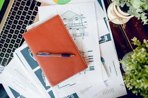 Business desk with business notebook, desk, pen, paper, table graph, top view with copy space photo