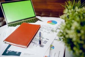 Business desk with business notebook, desk, pen, paper, table graph, top view with copy space photo
