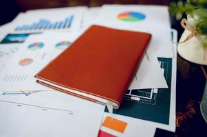 Business desk with business notebook, graph paper, pen on desk, top view with copy space. photo