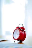 Old red alarm clock, red alarm clock Placed in the workspace. White room Beautiful colors. photo