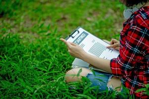 Hand of staff, marketing manager pointing to business documents and sitting under the tree - Business ideas photo