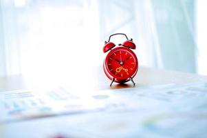 Old red alarm clock, red alarm clock Placed in the workspace. White room Beautiful colors. photo