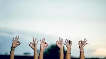 las manos de los jóvenes muestran alegría. concepto de trabajo en equipo feliz en el paraíso y hay un espacio de copia. foto