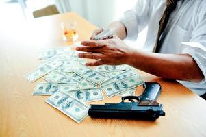 Businessmen with money in hand, US dollars, investment, success and profitable business ideas. Businessman with a firearm. photo