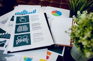 Business desk with business notebook, graph paper, pen on desk, top view with copy space. photo