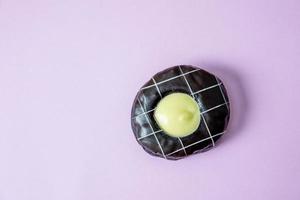 Donut chocolate Cover with chocolate and sprinkle with donuts. Lay on a pink background. photo