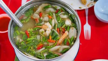 Clear soup Tom Yum Kung. Famous food of Thailand. It is sour, spicy, mellow and delicious. Ingredients fresh shrimp, various types of mushrooms, kaffir lime leaves, fresh chili photo