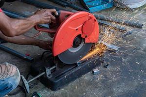 Worker cut steel with cut off wheel saw, cutting wheels. photo