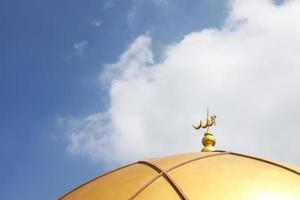 The inscription ALLAH on gold dome on blue sky for muslim concept background photo