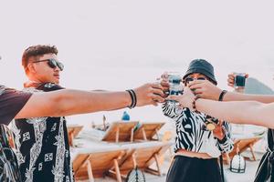 grupo de amigos asiáticos animando con cócteles tropicales azules en vacaciones de verano foto