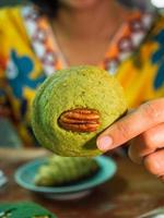 primer plano de la mano de una mujer sosteniendo una galleta de nuez. foto