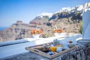 jugo fresco de la mañana y preparación del desayuno. Pareja viajando y destino de luna de miel, mañana idílica escénica, brillante vista de la caldera en Grecia, isla de Santorini. paisaje romántico, felicidad foto