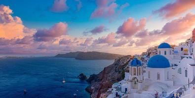 Fantastic sunset landscape of famous travel and vacation destination. Luxury summer adventure concept. Wonderful view of Oia village, Santorini, Greece. Hotels with pools and amazing architecture photo