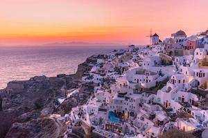 vista nocturna del atardecer del pueblo griego tradicional oia en la isla de santorini en grecia. santorini es un destino turístico icónico en grecia, famoso por sus puestas de sol y su arquitectura blanca tradicional foto