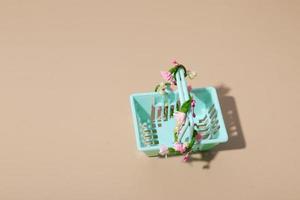 Empty shopping basket with flowers on a beige background. Minimalism. Spring sales, shopping, prices concept photo