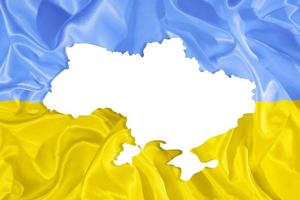 Ukrainian yellow and blue fabric flag and country map silhouette with copy space photo