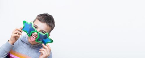 Banner with cheerful boy in funny glasses shows his tongue. April fool's day celebration concept with copy space photo