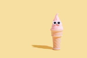 Ice cream cone in a waffle glass with sunglasses. Summer vacation in hot weather minimalistic concept photo
