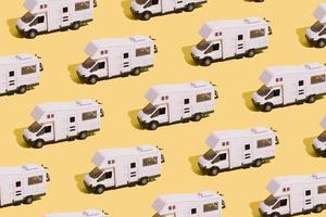 Irpin, Ukraine, June 10, 2021 - Pattern of a toy van on a yellow background. Minimalistic summer family vacation concept photo