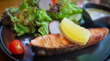 Grilled salmon fillet served with mixed green salad and keto cream salad dressing.