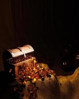 Golden Coins and vintage treasure chest made of wooden panels Reinforced with gold metal and gold pins Treasure boxes placed on the sand in a cave or treasure chest underwater. 3d Rendering photo