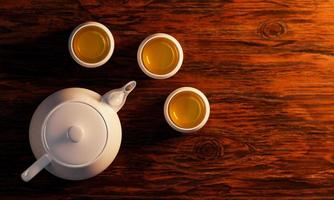 White ceramic teacup and white teapot on a wooden surface. Top view of drink sets 3D Rendering photo