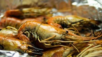 Grilled Shrimp with Seafood Sauce Contained in aluminum foil food wrap and foam food container. Thai style seafood sauce, spicy and sour taste, main ingredient, lime juice, fresh chili, fish sauce photo