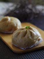 Steamed bun made with brown rice Placed on a wooden cutting board and the background blurred. photo