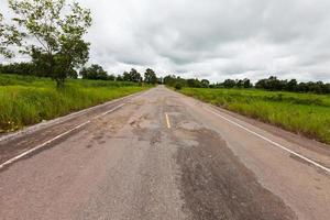 Damaged asphalt pavement road with potholes photo