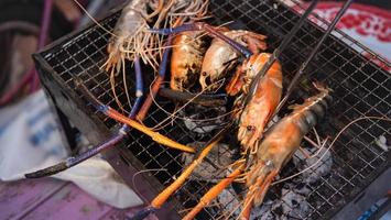 The shrimp are grilled on the grill or on the stove. Cooking grilled seafood at home. Big shrimp on the stove. It's turning orange and it's ripe. photo