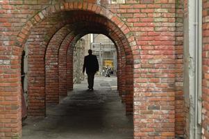 man walks in a brick tunnel photo