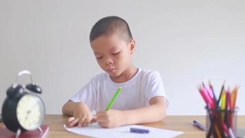 boy sitting and doing homework, drawing, coloring video