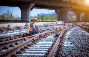 Engineer railway under  checking construction process train testing and checking railway work on railroad station with radio communication .Engineer wearing safety uniform and safety helmet in work. photo