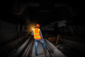 Engineer railway under  checking construction process train testing and checking railway work on railroad station with radio communication .Engineer wearing safety uniform and safety helmet in work. photo