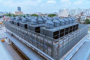 Industry engineer under checking the industry cooling tower air conditioner is water cooling tower air chiller HVAC of large industrial building to control air system. photo