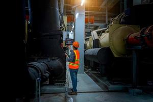 Industry engineer under checking the industry cooling tower air conditioner is water cooling tower air chiller HVAC of large industrial building to control air system. photo