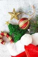 Christmas background in top view with candy cane, pine branch, glitter star, red ornament ball and Santa Claus hat. photo