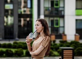 mujer caucásica bebiendo café para llevar foto