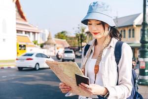 Attractive young hipster adult traveller asian woman using map for travel photo