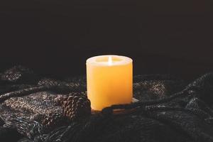 Cozy in winter aroma candle with pine corn on sweater shirt photo