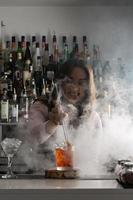 Cheerful bartender making cocktail in bar photo